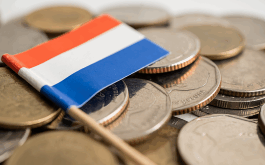 Drapeau luxembourgeois sur un tas de pièces pour illustrer la notion de crédit d'impôt immobilier dans ce pays
